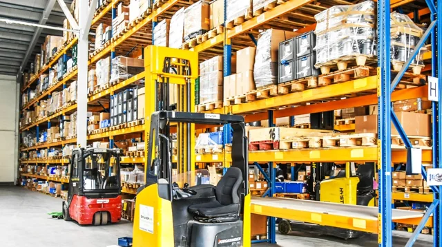 Palletised goods and forklifts in a warehouse